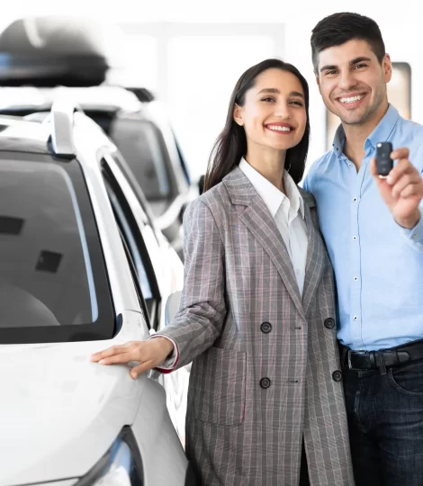 family-showing-car-key-standing-in-dealership-store